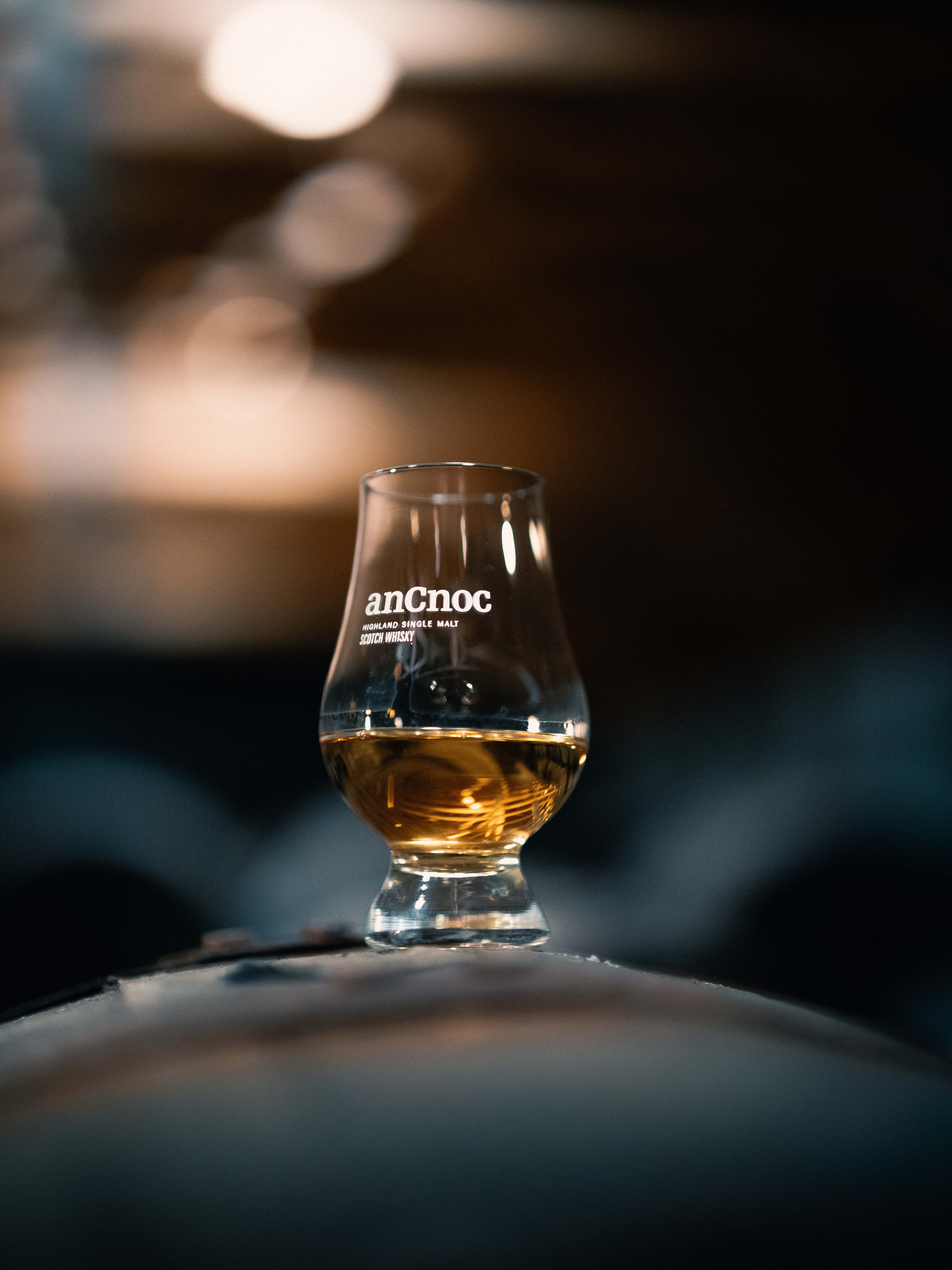 A small glass of whisky. The glass has letters on it reading 'anCnoc'